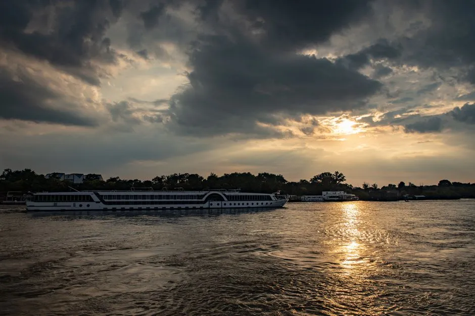 River cruise ship sailing on a European river at sunset